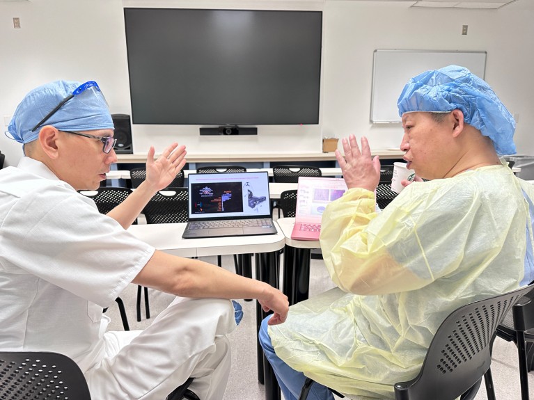 Qingping Xie (right) talks with Wei Chen (left) at the Cleveland Clinic.