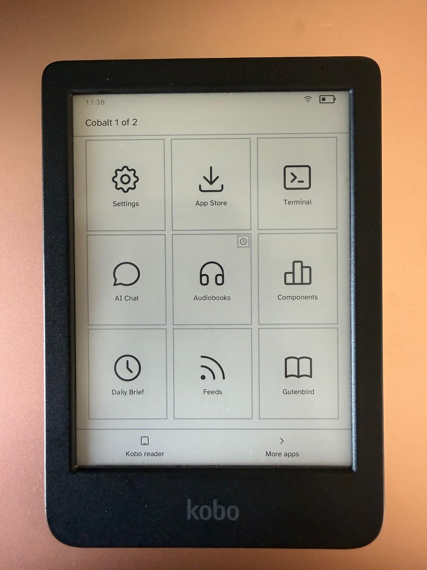 Лаунчер Cobalt на Kobo Clara BW, показывающий Settings, App Store, Terminal, AI Chat, Audiobooks, Components, Daily Brief, Feeds и Gutenbird