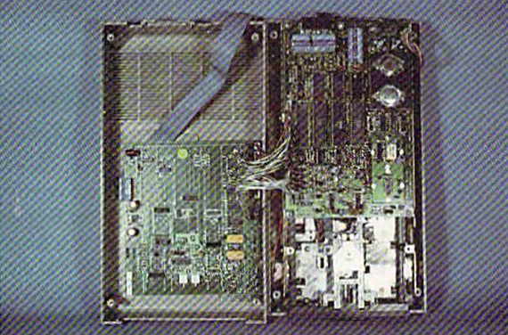 Разобранный привод 1541 справа с подключённой картой DOS от Mimic Systems слева. Несколько кабелей-перемычек соединяют две платы.