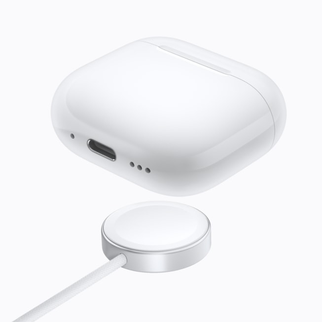 AirPods 5 с беспроводным чехлом для зарядки показаны над зарядным устройством.